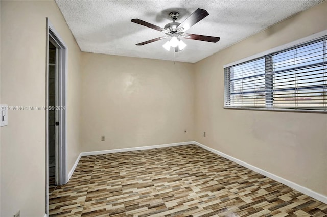 empty room with ceiling fan, hardwood / wood-style flooring, and a textured ceiling