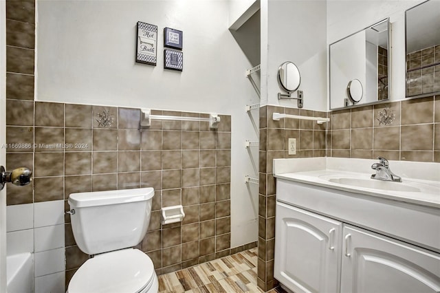 full bathroom with tile walls, vanity, and toilet