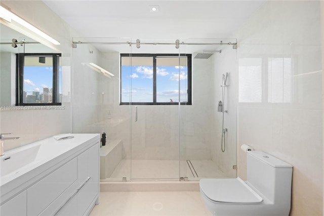 bathroom with toilet, an enclosed shower, a wealth of natural light, and tile walls