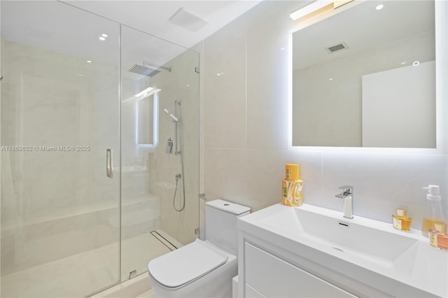 bathroom featuring vanity, backsplash, tile walls, toilet, and a shower with shower door