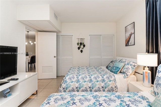 tiled bedroom with a chandelier