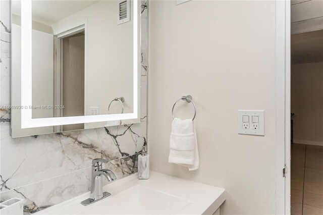 bathroom featuring vanity, tile patterned floors, and decorative backsplash