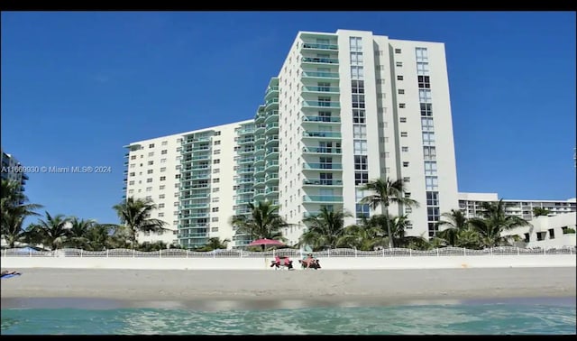 view of property with a water view and a beach view