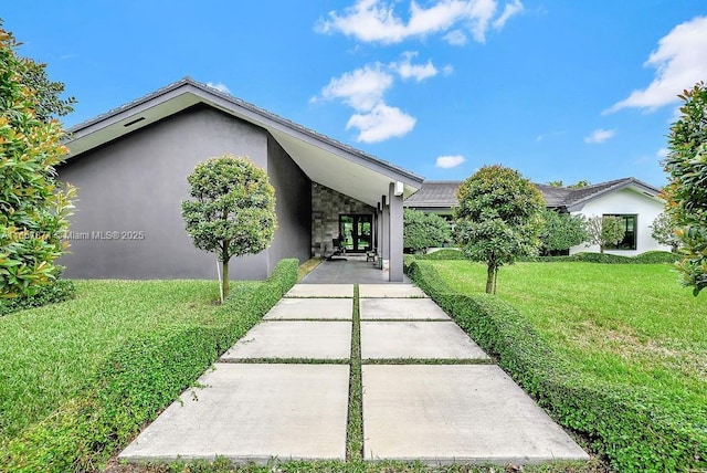 view of front of house featuring a carport and a front yard