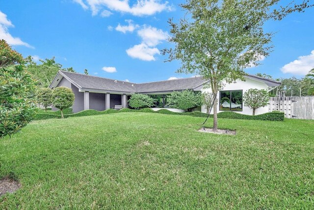 back of house with a fenced in pool, a lawn, and a patio