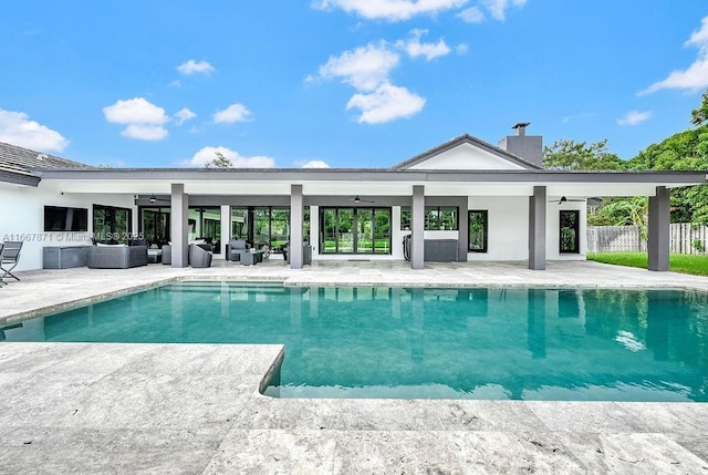 view of swimming pool with an outdoor living space, ceiling fan, and a patio area