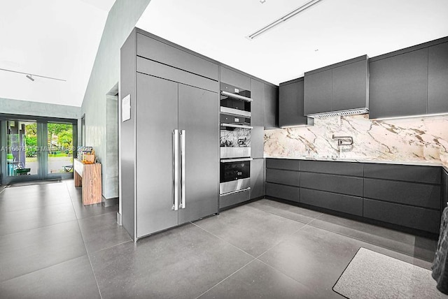 kitchen with tasteful backsplash, paneled refrigerator, french doors, and stainless steel double oven