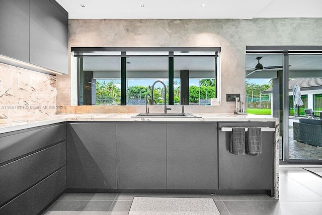 kitchen featuring gray cabinets, tasteful backsplash, sink, and light tile patterned floors