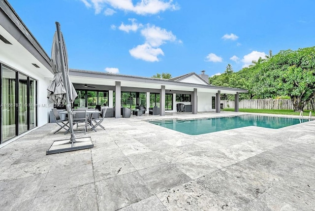 view of swimming pool featuring ceiling fan and a patio