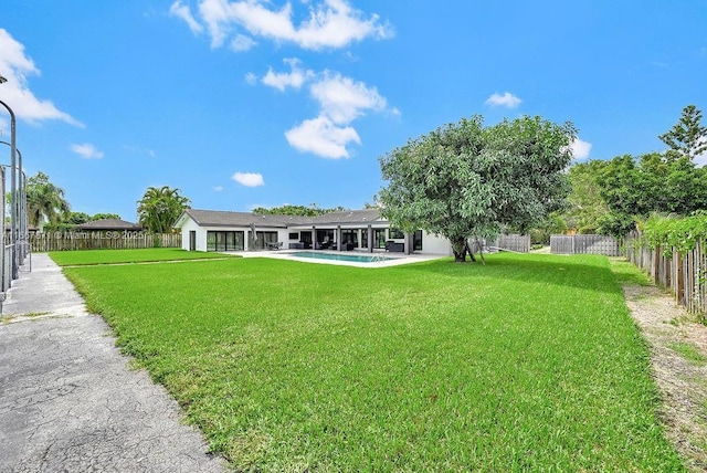 view of yard with a fenced in pool and a patio area