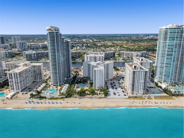 birds eye view of property featuring a water view, a view of city, and a beach view