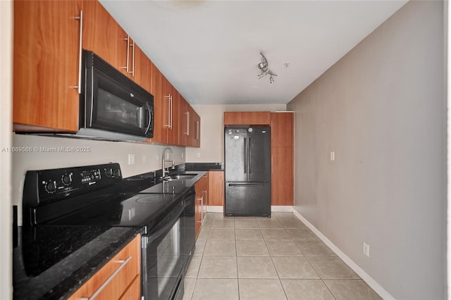 kitchen featuring baseboards, brown cabinets, black appliances, a sink, and light tile patterned flooring