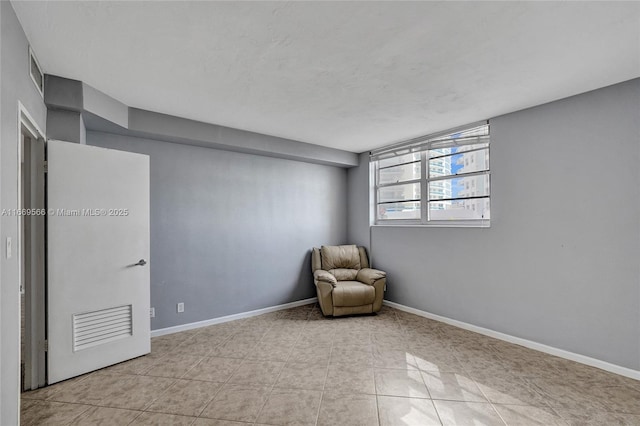 unfurnished room featuring light tile patterned floors and baseboards