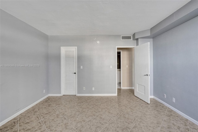 unfurnished room with visible vents and baseboards