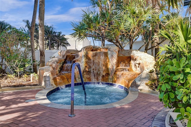 view of swimming pool featuring an in ground hot tub and fence