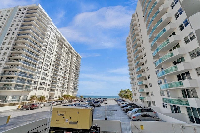 view of building exterior with uncovered parking and a water view