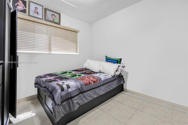 bedroom featuring baseboards and light tile patterned floors