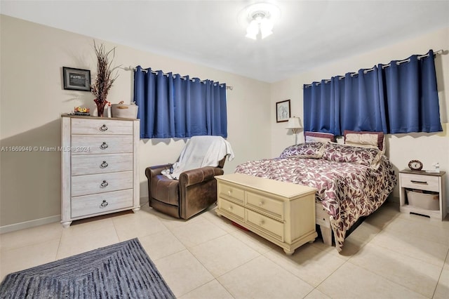 bedroom with baseboards and light tile patterned floors