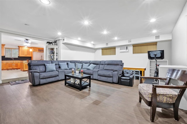 living room featuring light hardwood / wood-style floors and ceiling fan