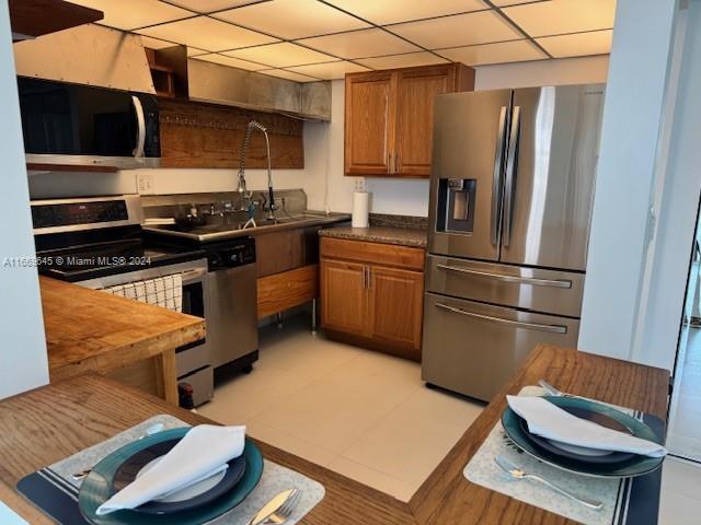 kitchen with a drop ceiling, stainless steel appliances, and sink