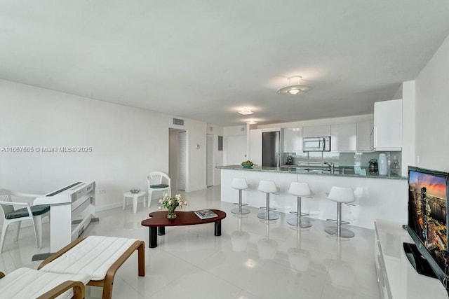 living area featuring visible vents and light tile patterned floors