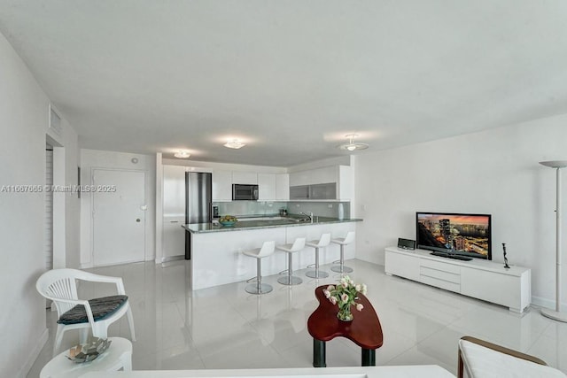 living room featuring baseboards and light tile patterned floors