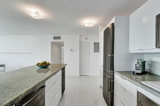 kitchen featuring high quality fridge, white cabinetry, beverage cooler, and light stone counters