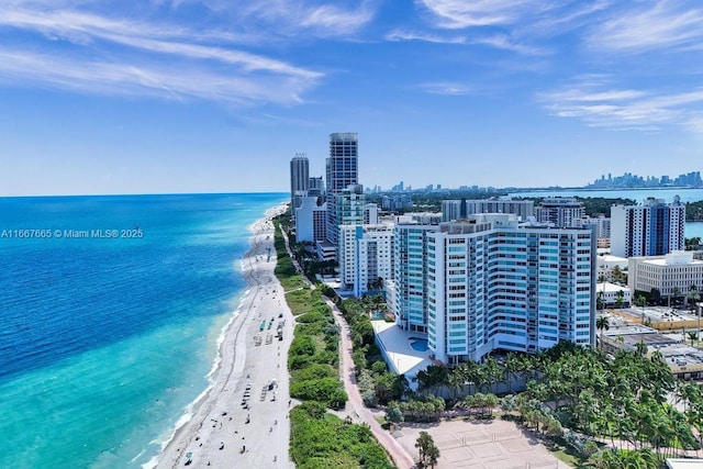 birds eye view of property with a water view and a view of the beach