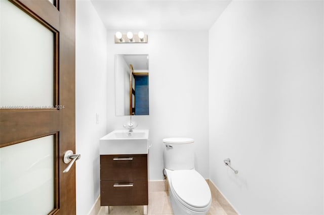 bathroom with tile patterned flooring, vanity, and toilet