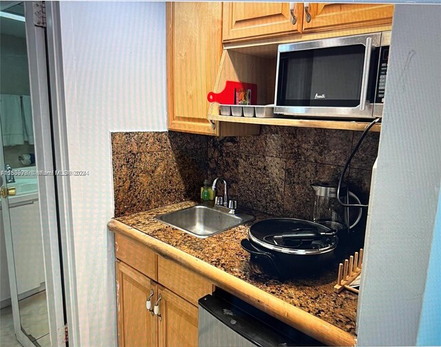 kitchen featuring stone counters, sink, and tasteful backsplash