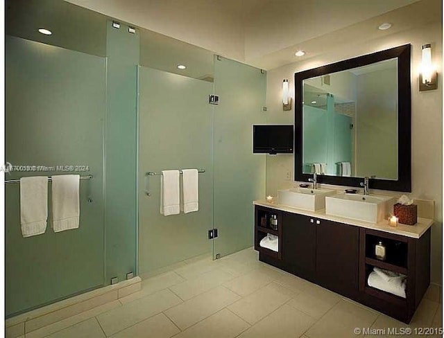 bathroom with tile patterned flooring, a shower with door, and vanity