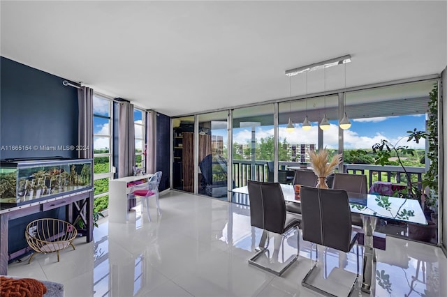 tiled dining space featuring a wall of windows and plenty of natural light