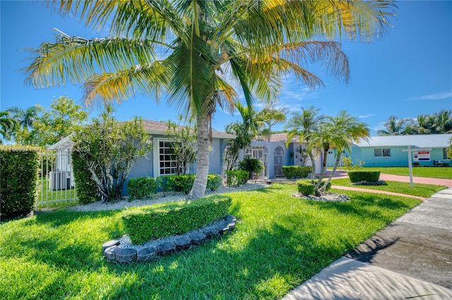 view of front of house featuring cooling unit and a front yard