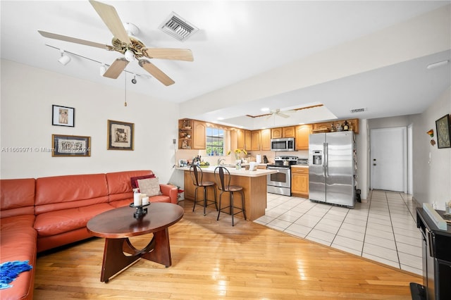 living room with light hardwood / wood-style flooring and ceiling fan