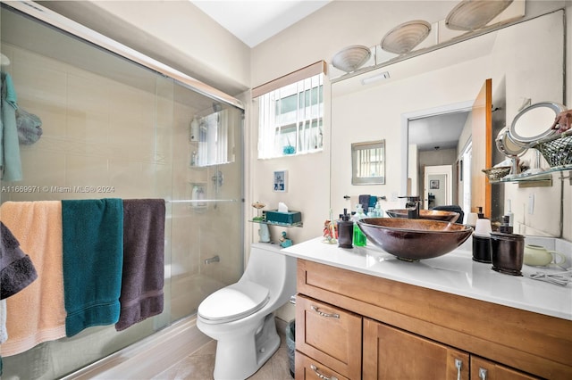 bathroom featuring vanity, toilet, and an enclosed shower