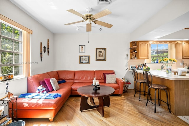 living room featuring ceiling fan and light hardwood / wood-style flooring