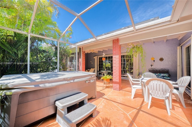 view of patio featuring a hot tub, glass enclosure, and ceiling fan