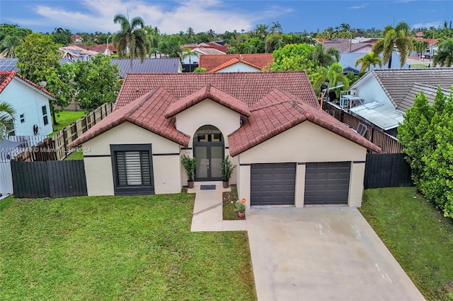 mediterranean / spanish-style home with a garage and a front lawn