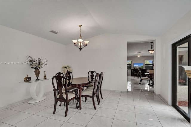 dining space with ceiling fan with notable chandelier, lofted ceiling, and light tile patterned floors