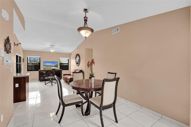 dining space featuring light tile patterned floors, lofted ceiling, and ceiling fan