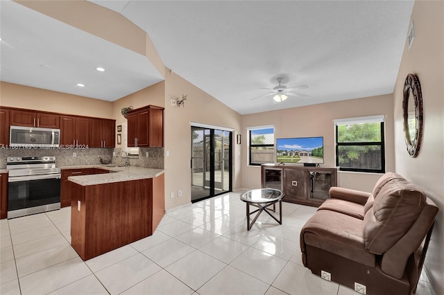 kitchen with ceiling fan, kitchen peninsula, tasteful backsplash, stainless steel appliances, and vaulted ceiling