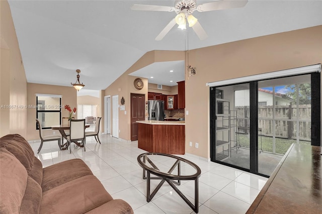 living room featuring lofted ceiling, light tile patterned floors, and a healthy amount of sunlight