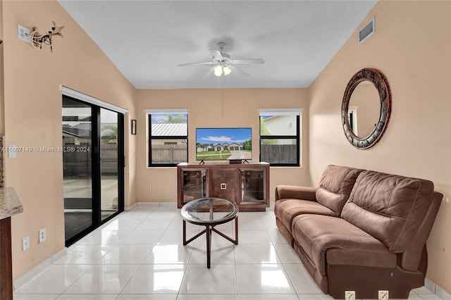 living room featuring vaulted ceiling, ceiling fan, and light tile patterned floors