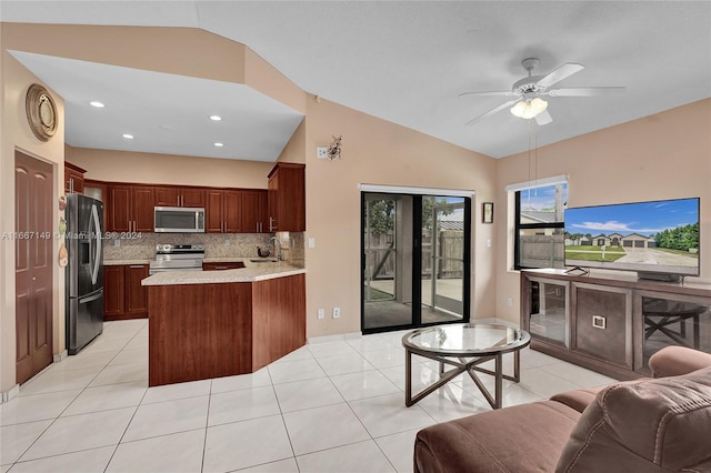 kitchen with appliances with stainless steel finishes, light tile patterned flooring, kitchen peninsula, lofted ceiling, and ceiling fan