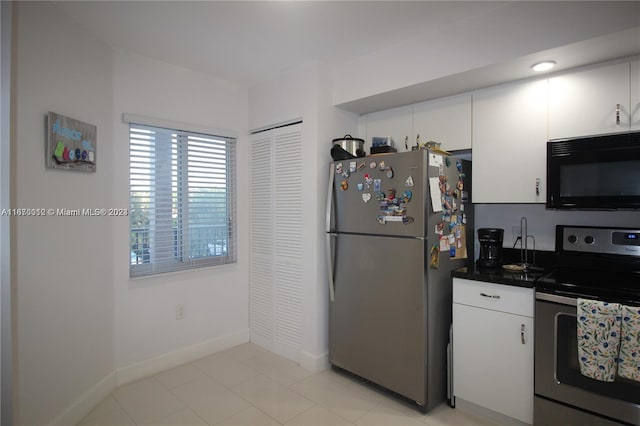 kitchen featuring stainless steel appliances, white cabinets, and light tile patterned flooring