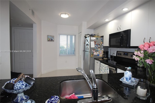 kitchen featuring sink, white cabinetry, black appliances, light tile patterned floors, and dark stone countertops