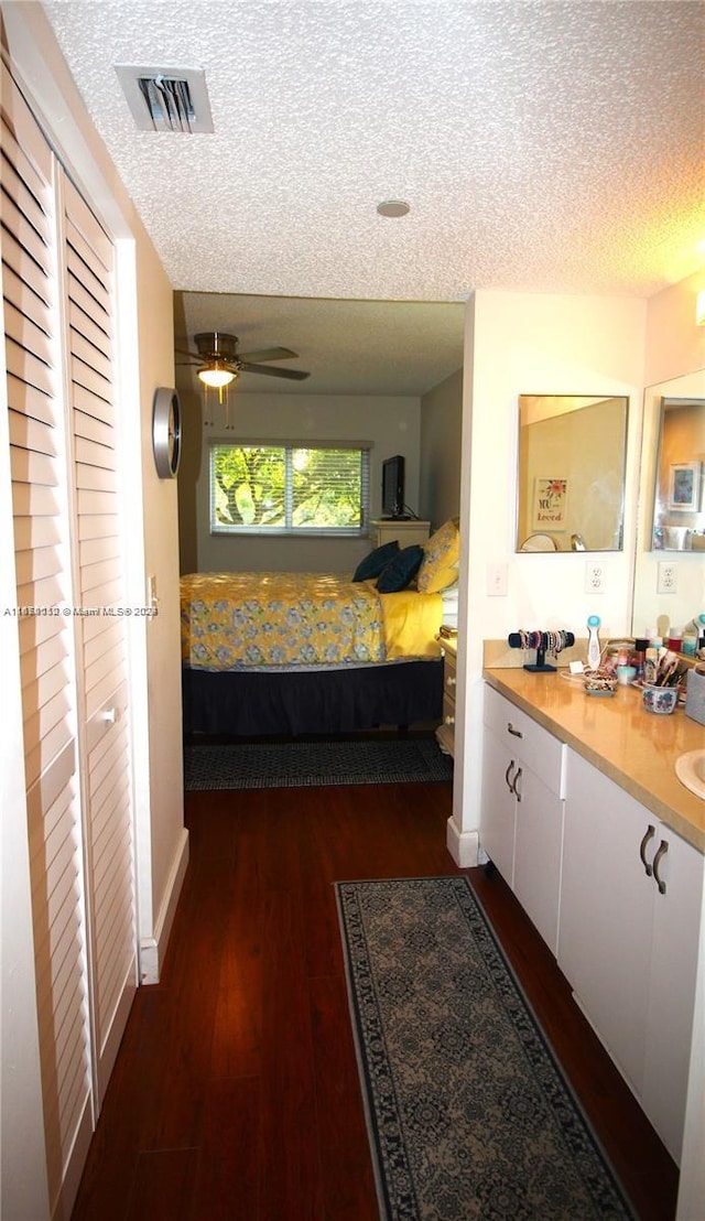 interior space featuring ceiling fan, a textured ceiling, and dark hardwood / wood-style floors