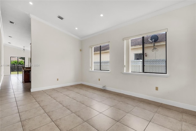 unfurnished room with light tile patterned flooring, lofted ceiling, plenty of natural light, and ornamental molding