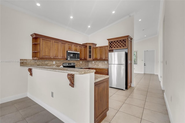 kitchen featuring light tile patterned flooring, ornamental molding, kitchen peninsula, appliances with stainless steel finishes, and a kitchen bar