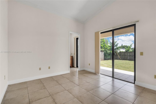 tiled spare room with vaulted ceiling